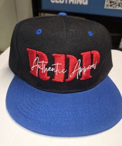 The RDP Authentic Apparel Signature Snapback features bold 3D red embroidery with a white "Authentic Apparel" script overlay, paired with a classic black crown and royal blue flat brim.
